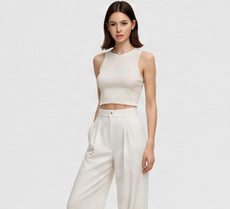 Model wearing an ivory sleeveless top and matching wide-leg trousers