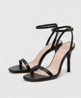 Black open-toe heeled sandals with slim ankle straps